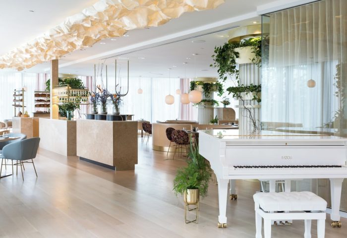Interior of Fairmont Pacific Rim Hotel, a gay-friendly hotel. White piano, plants, and modern design. Upscale dining for gay travelers.