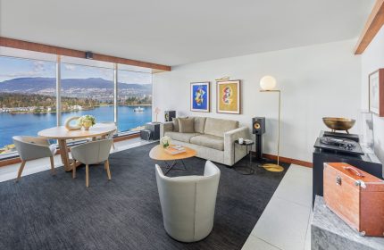 Fairmont Pacific Rim Hotel suite. Living area with ocean view, sofa, table, and chairs. Gay-friendly hotel for gay men's travel advice.