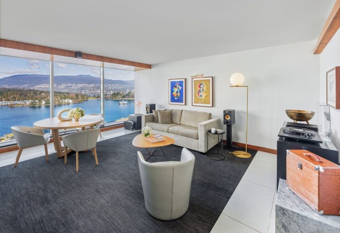 Fairmont Pacific Rim Hotel suite. Living area with ocean view, sofa, table, and chairs. Gay-friendly hotel for gay men's travel advice.