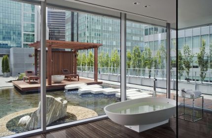 Fairmont Pacific Rim Hotel gay-friendly suite. Bathtub, pond, & lounge chairs on a patio with city views. Luxury gay travel in Vancouver.