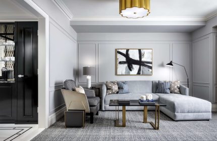Fairmont Royal York gay-friendly hotel room. Modern decor with gray sofa, patterned pillows, and abstract art. Upscale and stylish.