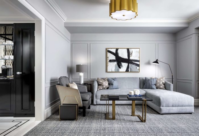 Fairmont Royal York gay-friendly hotel room. Modern decor with gray sofa, patterned pillows, and abstract art. Upscale and stylish.