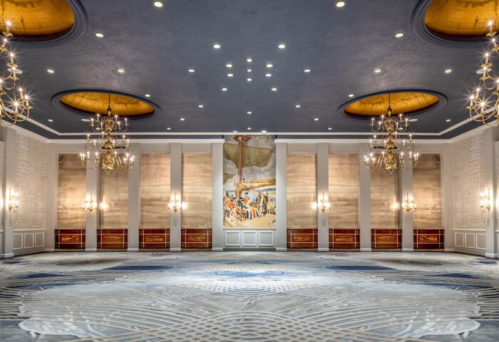 Fairmont Royal York gay-friendly hotel ballroom. Elegant interior with chandeliers, mural, patterned carpet, and blue ceiling.
