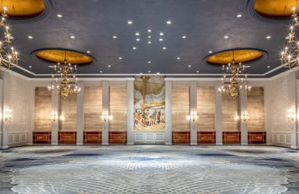 Fairmont Royal York gay-friendly hotel ballroom. Elegant interior with chandeliers, mural, patterned carpet, and blue ceiling.