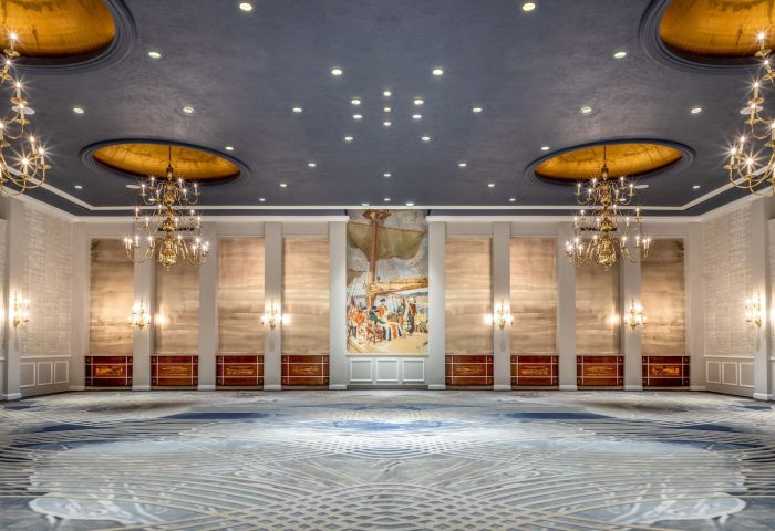 Fairmont Royal York gay-friendly hotel ballroom. Elegant interior with chandeliers, mural, patterned carpet, and blue ceiling.