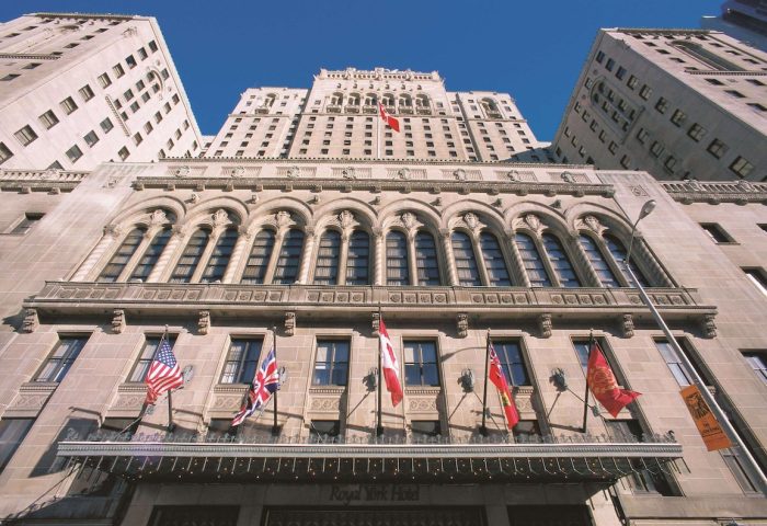 Facade of Fairmont Royal York, a gay-friendly hotel. Flags of different countries adorn the hotel's exterior. Toronto, Canada.