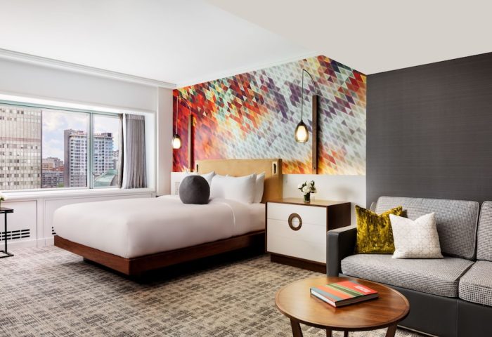 Fairmont The Queen Elizabeth Hotel room. Gay-friendly hotel with modern decor, city view, bed, and sofa. Ideal for gay men travel.
