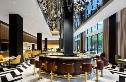 Fairmont The Queen Elizabeth hotel bar interior. Upscale, gay-friendly hotel with stylish decor, seating, and a unique ceiling design.