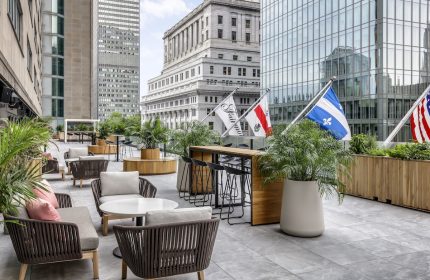 Fairmont The Queen Elizabeth gay-friendly hotel patio. Outdoor seating, bar, and flags. A great choice for gay men's travel in Montreal.