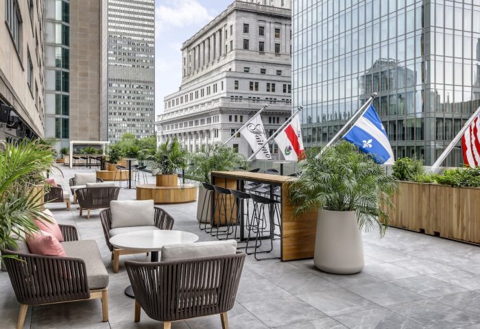 Fairmont The Queen Elizabeth gay-friendly hotel patio. Outdoor seating, bar, and flags. A great choice for gay men's travel in Montreal.