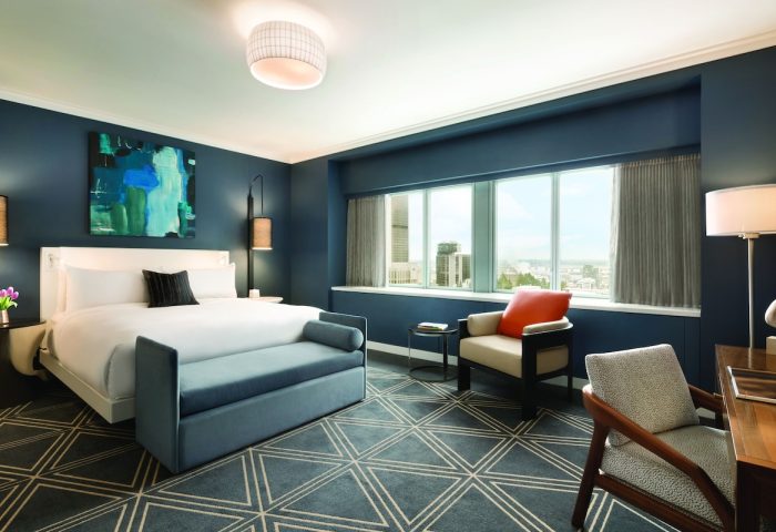 Fairmont The Queen Elizabeth hotel room. Gay-friendly hotel with a bed, chair, desk, and city view. Luxury travel for gay men.