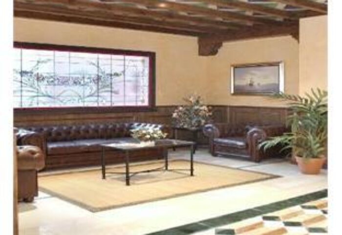 Lobby at Fenix Torremolinos, Adults Only hotel. Gay-friendly recommended hotel with brown leather sofas, wood accents, and tile flooring.