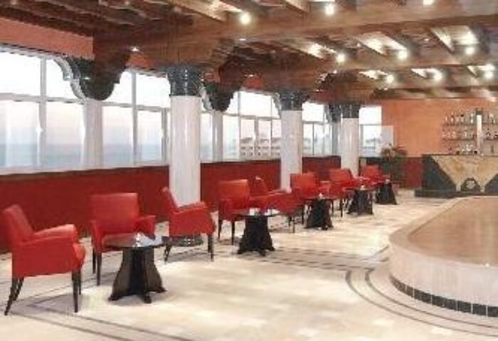 Fenix Torremolinos Adults Only Hotel lounge area. Gay-friendly recommended hotel with red chairs, tables, bar, and unique ceiling design.