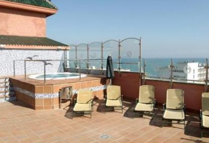 Rooftop terrace at Fenix Torremolinos, an adults-only, gay-friendly hotel. Features a jacuzzi, lounge chairs, and ocean views. Recommended hotel.