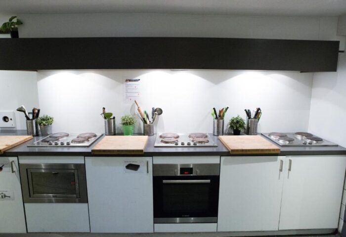 Kitchen at Flying Pigs Downtown Hostel, Amsterdam. Gay-friendly hotel with cooking facilities. Ovens, hobs, and utensils for guests' use.