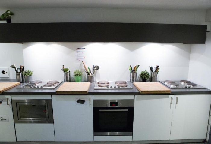 Kitchen at Flying Pigs Downtown Hostel, Amsterdam. Gay-friendly hotel with cooking facilities. Ovens, hobs, and utensils for guests' use.