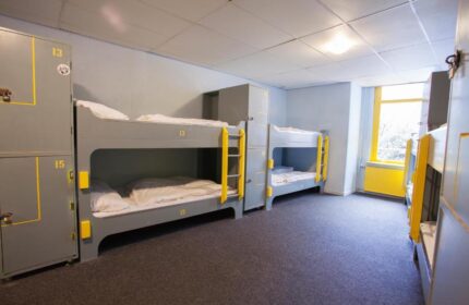 Flying Pigs Downtown Hostel Amsterdam dorm room. Bunk beds with yellow accents. Gay-friendly hotel for travelers.