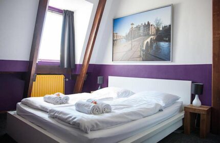 Gay-Friendly Flying Pigs Downtown Hostel Amsterdam bedroom. Double bed, Amsterdam canal print, and window. Gay travel accommodation.