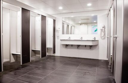 Bathroom at Flying Pigs Downtown Hostel, Amsterdam. Gay-friendly hotel with lockers, sinks, mirror, and tiled floor. Budget travel for gay men.