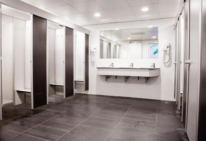 Bathroom at Flying Pigs Downtown Hostel, Amsterdam. Gay-friendly hotel with lockers, sinks, mirror, and tiled floor. Budget travel for gay men.