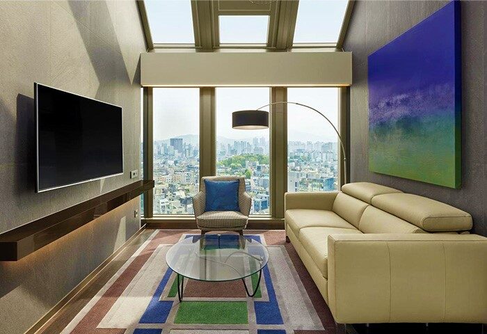 Four Points by Sheraton Seoul, Gangnam suite. Gay-friendly hotel room with city view, sofa, and TV. Modern, stylish design.