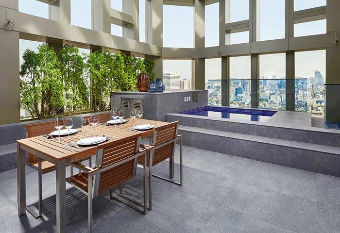 Four Points by Sheraton Seoul, Gangnam gay-friendly hotel rooftop dining area with city view, pool, table set for a meal.