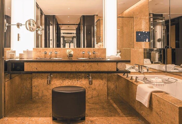 Luxury bathroom at the gay-friendly Four Seasons Hotel Hong Kong. Marble finishes, double sinks, soaking tub, and a modern design.