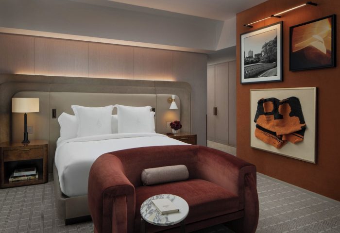 Four Seasons Hotel New York Downtown room. Gay-friendly hotel with bed, red couch, & art. Luxury lodging for gay men travelers.