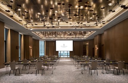 Four Seasons Hotel New York Downtown ballroom. Gay-friendly hotel with modern lighting, tables, and chairs set up for a meeting.