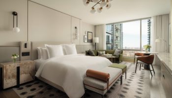 Four Seasons Hotel Toronto at Yorkville: Gay-friendly hotel room with a king-size bed, sitting area, and city view. Luxury gay travel.