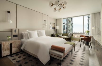 Four Seasons Hotel Toronto at Yorkville: Gay-friendly hotel room with a king-size bed, sitting area, and city view. Luxury gay travel.