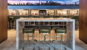 Four Seasons Hotel Toronto at Yorkville bar area. Stylish interior with Toronto skyline backdrop. Gay-friendly hotel with luxury design.