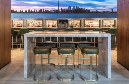 Four Seasons Hotel Toronto at Yorkville bar area. Stylish interior with Toronto skyline backdrop. Gay-friendly hotel with luxury design.