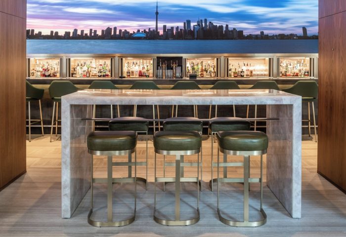 Four Seasons Hotel Toronto at Yorkville bar area. Stylish interior with Toronto skyline backdrop. Gay-friendly hotel with luxury design.