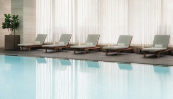 Poolside lounge chairs at Four Seasons Hotel Toronto at Yorkville. Gay-friendly hotel with luxury amenities. Relaxing travel for gay men.