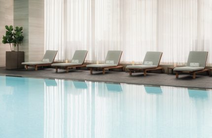 Poolside lounge chairs at Four Seasons Hotel Toronto at Yorkville. Gay-friendly hotel with luxury amenities. Relaxing travel for gay men.