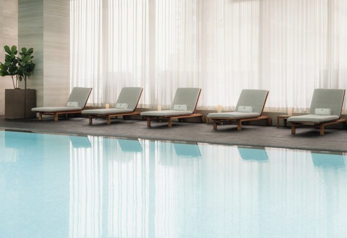 Poolside lounge chairs at Four Seasons Hotel Toronto at Yorkville. Gay-friendly hotel with luxury amenities. Relaxing travel for gay men.