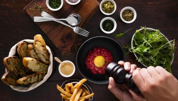 Fine dining at Four Seasons Hotel Toronto. Steak tartare with fries, toast, salad, and condiments. Gay-friendly hotel in Yorkville.