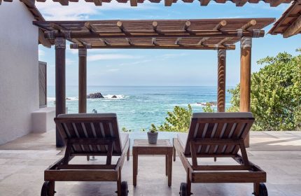 Four Seasons Resort Punta Mita gay-friendly hotel ocean view. Two lounge chairs on a patio overlooking the Pacific. Vacation travel.