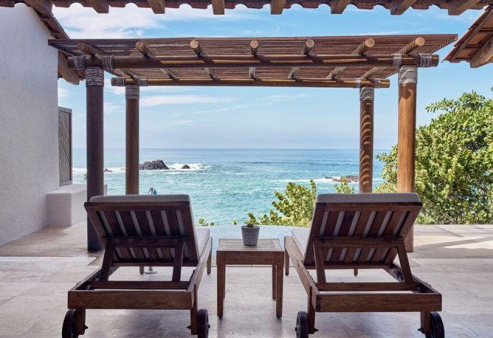 Four Seasons Resort Punta Mita gay-friendly hotel ocean view. Two lounge chairs on a patio overlooking the Pacific. Vacation travel.
