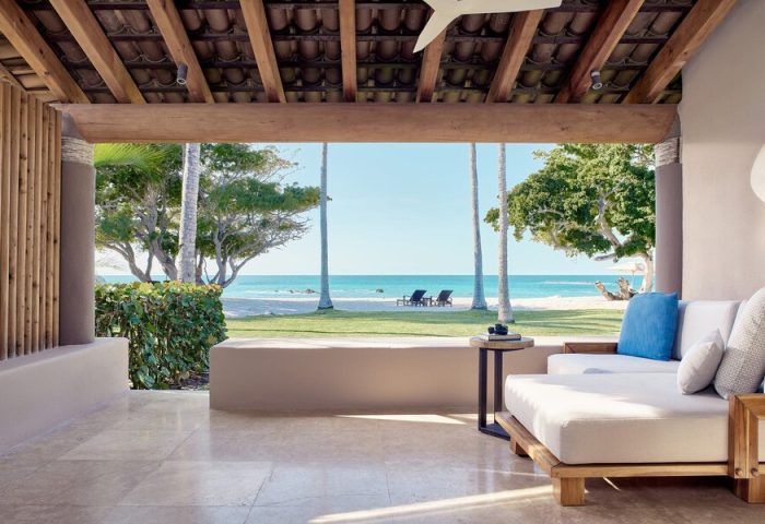 Four Seasons Resort Punta Mita, a gay-friendly hotel. Ocean view from a suite's patio with lounge seating. Beach chairs visible.
