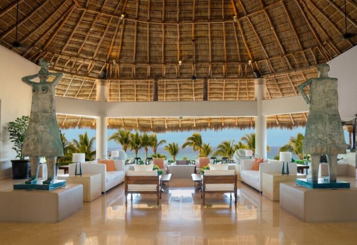 Lobby at Four Seasons Resort Punta Mita, a gay-friendly hotel. Statues flank seating with ocean view. Luxury travel for gay men.
