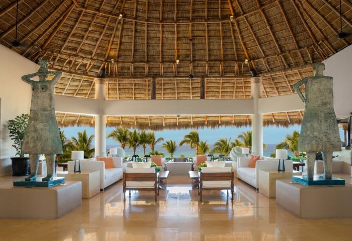 Lobby at Four Seasons Resort Punta Mita, a gay-friendly hotel. Statues flank seating with ocean view. Luxury travel for gay men.