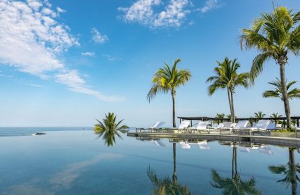 Four Seasons Resort Punta Mita: Poolside view with palm trees. Gay-friendly hotel in Punta Mita, perfect for a relaxing vacation.