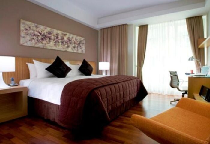 Bedroom at Fraser Place Kuala Lumpur, a gay-friendly hotel. Features a king bed, desk, and lounge chair. Ideal for gay travelers seeking comfort.