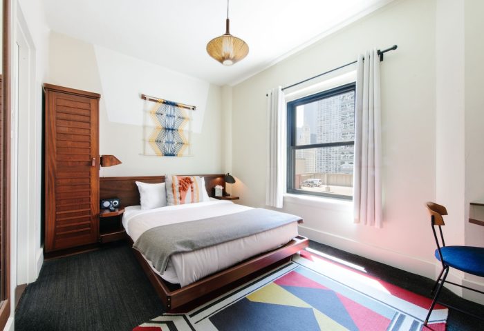 Freehand Chicago hotel room. Gay-friendly travel. Queen bed, wood furniture, colorful rug, city view. Modern decor. Chicago hotel.