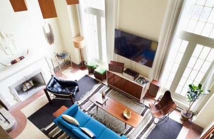 Freehand Chicago hotel room: stylish living space with blue sofa, fireplace, and mid-century modern decor. Gay-friendly hotel for LGBT travelers.
