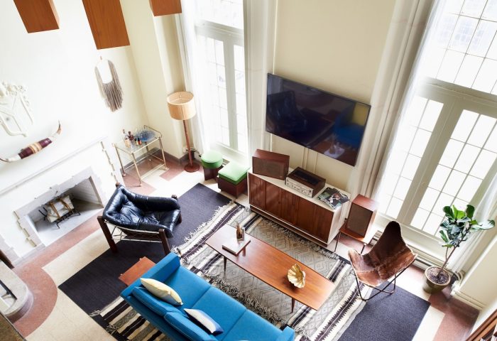 Freehand Chicago hotel room: stylish living space with blue sofa, fireplace, and mid-century modern decor. Gay-friendly hotel for LGBT travelers.