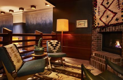 Freehand Chicago hotel lounge area with fireplace, chairs, and rug. A gay-friendly travel destination in Chicago. Interior design.