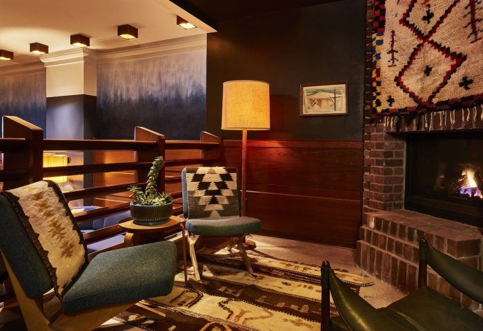 Freehand Chicago hotel lounge area with fireplace, chairs, and rug. A gay-friendly travel destination in Chicago. Interior design.